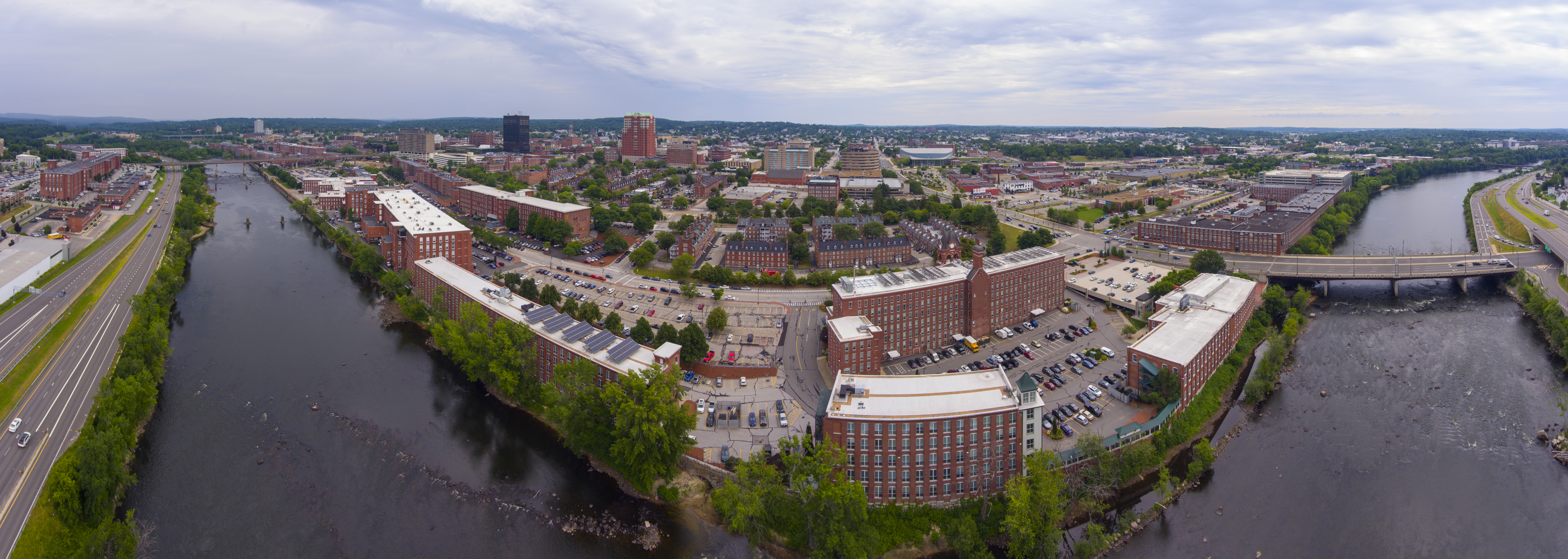 Manchester downtown building including City Hall Plaza and Brady Sullivan Plaza with Merrimack River in the front panorama aerial view, Manchester, New Hampshire, NH, USA.